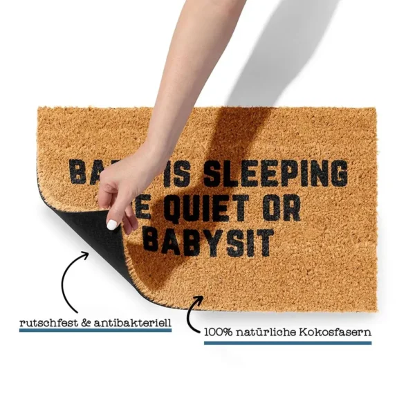 Detailansicht der Kokos Fußmatte mit 'Baby is Sleeping Be Quiet or Babysit', Hinweis auf Rutschfestigkeit und 100% natürliche Kokosfasern